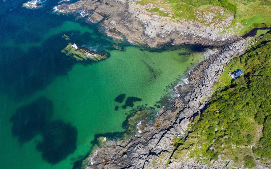 Aerial shot of waves lapping up onto rocks in Portuairk Bay, Ardnamurchan, Lochaber